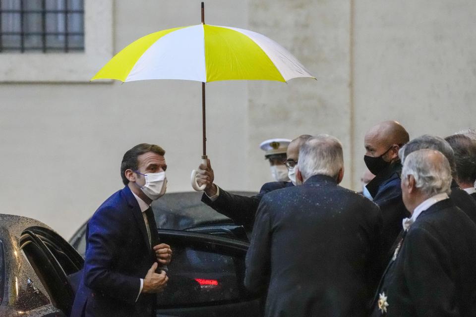 French President Emmanuel Macron, left, arrives at the Vatican to meet Pope Francis, Friday, Nov. 26, 2021. (AP Photo/Andrew Medichini)