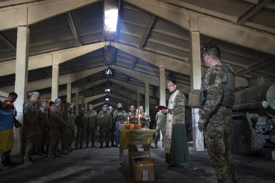 A military Orthodox priest leads a service during the Easter celebration at the frontline position of 128 brigade of Ukrainian army near Zaporizhzhia, Ukraine, Sunday, April 24, 2022. (AP Photo/Andriy Dubchak)