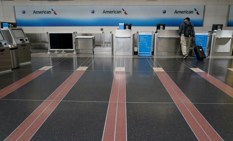 FILE PHOTO: FILE PHOTO: Customer seeks assistance at American Airlines counter at Reagan National airport in Washington