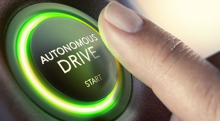 An image of a finger pressing an autonomous drive button; autonomous vehicles