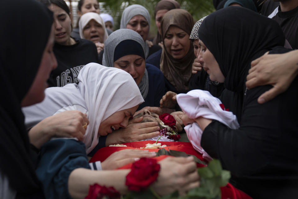 Palestinians mourn Nasser Barghouti during his funeral in the West Bank village of Beit Rima, northwest of Ramallah, Sunday, Oct. 29, 2023. Barghouthi was killed during an Israeli army raid in Bait Reema early morning, the Palestinian Ministry of Health said. (AP Photo/Nasser Nasser)