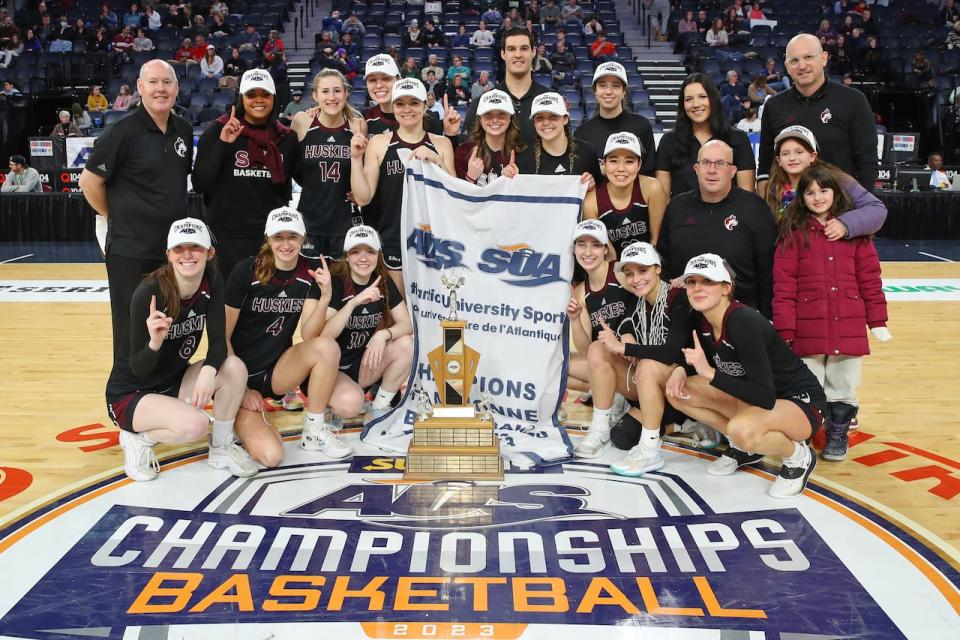 Clara Gascoigne (8) poses with teammates after defeating Acadia 68-56 in the AUS championship game in February.