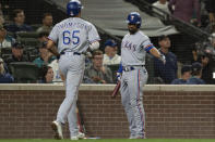 Texas Rangers' Bubba Thompson is congratulated by Marcus Semien after scoring a run during the eighth inning of the team's baseball game against the Seattle Mariners, Thursday, Sept. 29, 2022, in Seattle. (AP Photo/Stephen Brashear)