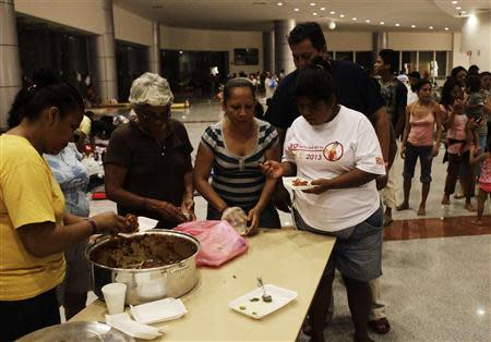 People receive food while camping out at a shelter after storms hit Acapulco September 20, 2013. REUTERS/Henry Romero