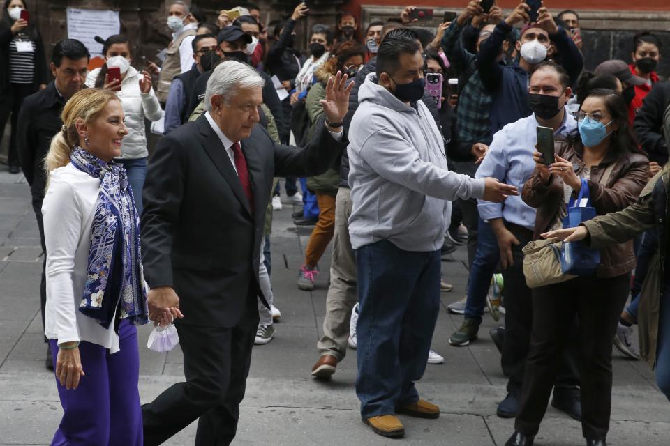 Mexico's President Andres Manuel Lopez Obrador waves to supporters as he walks with first lady Beatriz Gutierrez after voting in congressional, state and local elections in Mexico City, Sunday, June 6, 2021. Mexicans on Sunday were electing the entire lower house of Congress, almost half the country's governors and most mayors in a vote that will determine if Obrador's Morena party gets the legislative majority. (AP Photo/Marco Ugarte)