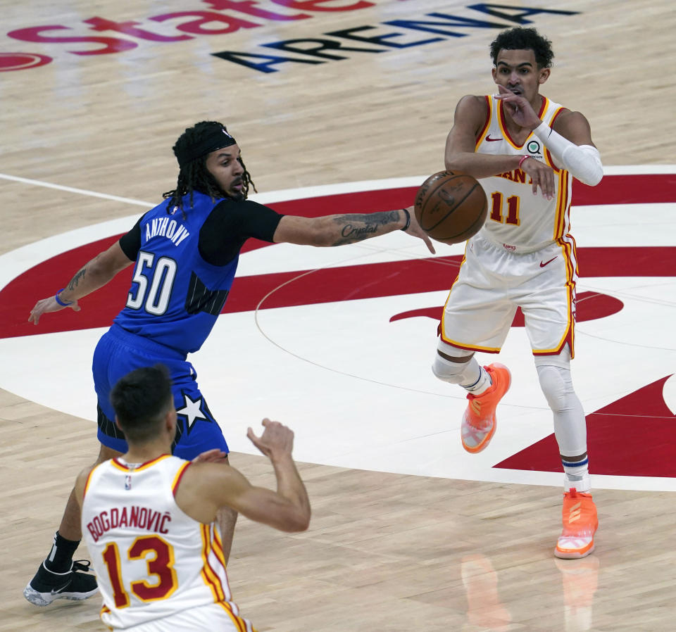 Orlando Magic guard Cole Anthony (50) defends Atlanta Hawks guard Trae Young (11) as he passes to teammate Bogdan Bogdanovic (13) in the second half of an NBA basketball game Thursday, May 13, 2021 in Atlanta. The Hawks defeated the Magic 116-93. (AP Photo/Tami Chappel)