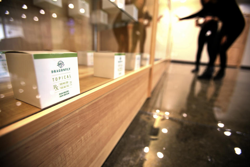 Workers prepare items in display cases for purchase as Dragonfly Wellness in Salt Lake City prepares to open as the first of Utah's 14 medical cannabis pharmacies on Monday, March 2, 2020. (Scott G Winterton/The Deseret News via AP)