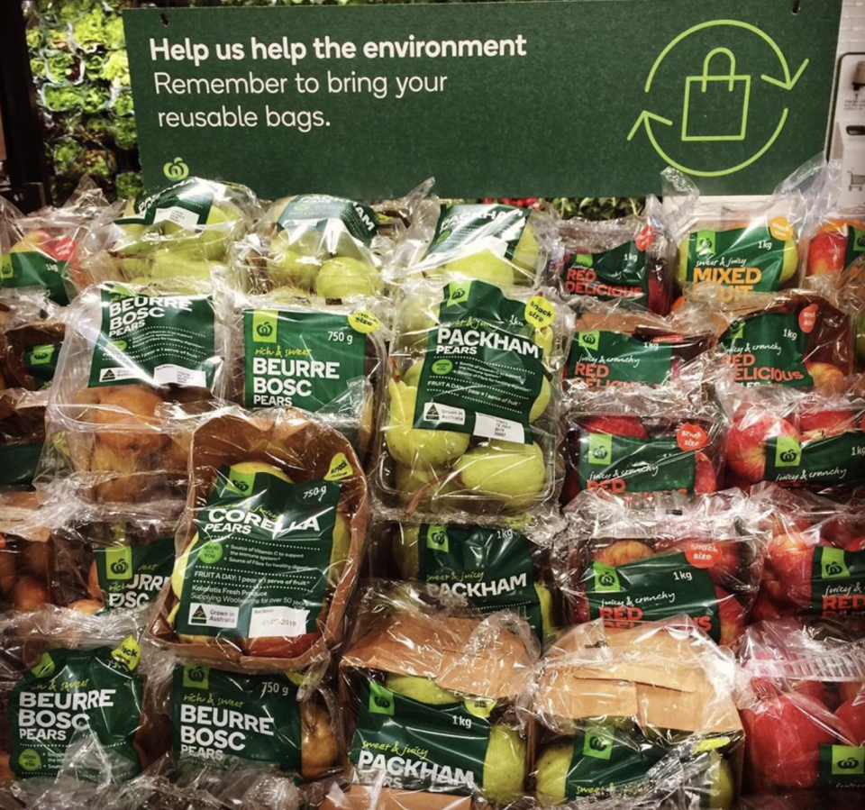 Selection of fresh fruit inside Woolworths store all wrapped in plastic.