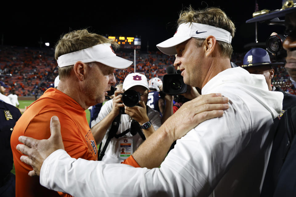 Auburn head coach Hugh Freeze (left) talks with Mississippi head coach Lane Kiffin after Mississippi's win on Saturday, Oct. 21, 2023, in Auburn, Ala. (AP Photo/Butch Dill )