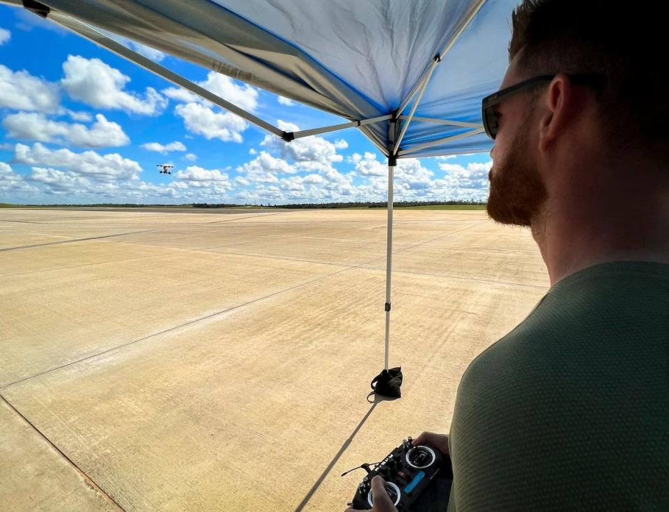 LIFT team member Luke Reddaway pilots the Hexa aircraft via remote control during its first flight at Duke Field.  The aircraft, which used 18 motors and propellers, flew for about 10 minutes and reached a height of some 50 feet.