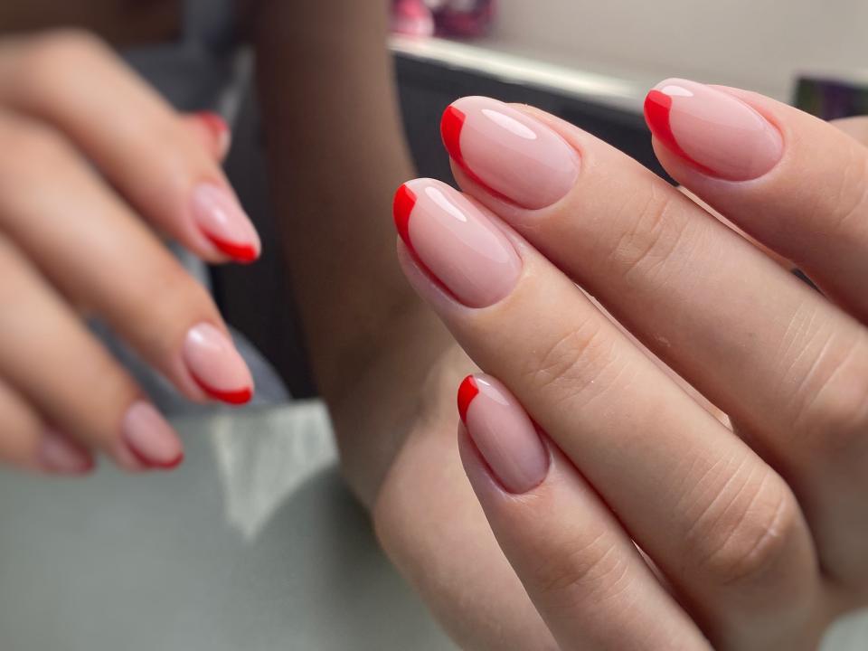 woman with red and beige french tip manicure