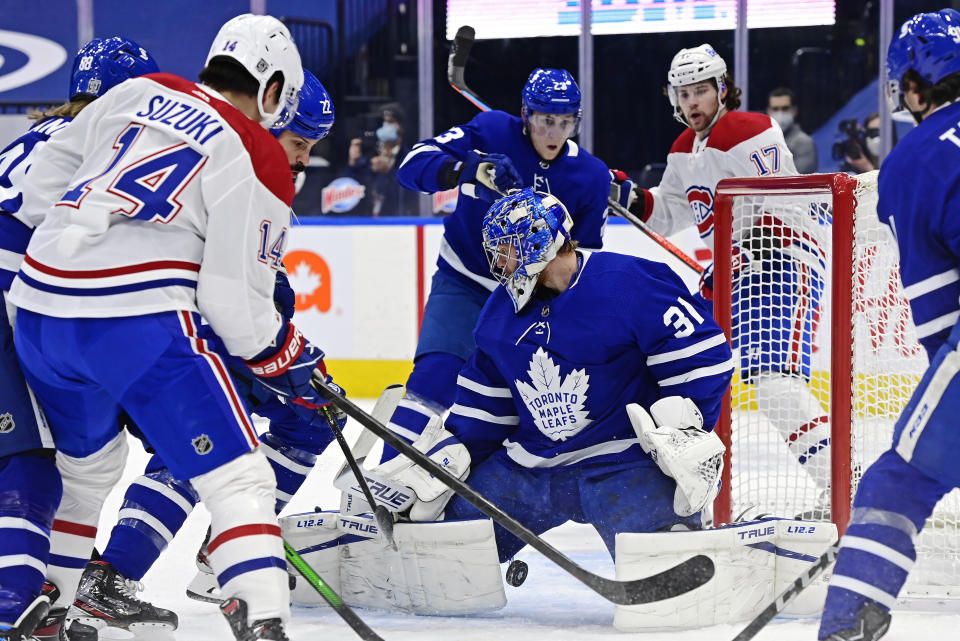 Toronto Maple Leafs goaltender Frederik Andersen (31) makes a save as Montreal Canadiens center Nick Suzuki (14) looks for the loose puck during the first period of an NHL hockey game in Toronto on Saturday, Feb. 13, 2021. (Frank Gunn/The Canadian Press via AP)