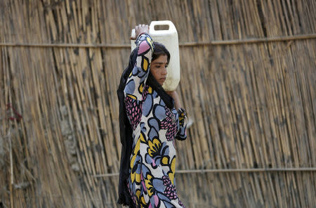 A girl carries a jerrycan filled with drinking water in a slum area on a hot summer day in New Delhi, India, April 27, 2016. REUTERS/Anindito Mukherjee