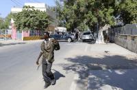 A Somali policeman walks outside the Central Hotel after a suicide attack in Somalia's capital Mogadishu February 20, 2015. Islamist rebels detonated a car bomb at the entrance of the hotel in the Somali capital on Friday and then stormed inside where politicians had gathered, killing at least 10 people including a lawmaker and lightly wounding two ministers. (REUTERS/Feisal Omar)