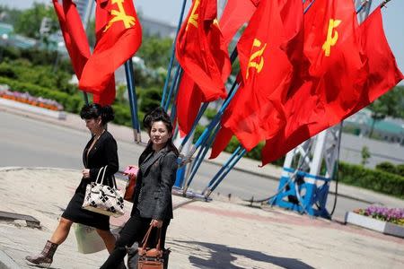 Workers' Party of Korea (WPK) flags decorate an intersection as women cross the street in central Pyongyang, North Korea, May 7, 2016. REUTERS/Damir Sagolj