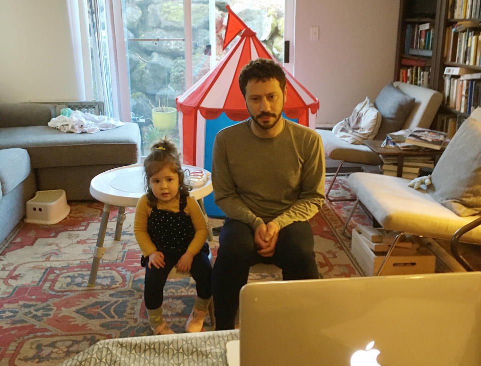 Kate Brumage's husband and daughter, Helen, video chat with family&nbsp;members. A tent has been set up in their living room for her daughter to play in. (Photo: Kate Brumage)