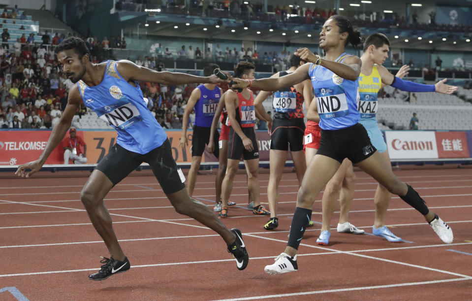 India's Hima Das, right, hands the baton to teammate Arokiarajiv during the 4x400m mixed relay final at the athletics competition at the 18th Asian Games in Jakarta, Indonesia, Tuesday, Aug. 28, 2018. (AP Photo/Lee Jin-man)