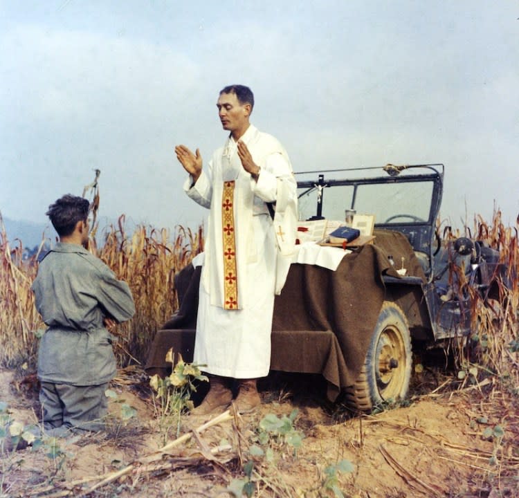 In this photo provided by Col. Raymond A. Skeehan, Father Emil Kapaun celebrates Mass using the hood of his jeep as an altar, as his assistant, Patrick J. Schuler, kneels in prayer in Korea on Oct. 7, 1950, less than a month before Kapaun was taken prisoner. Kapaun died in a prisoner of war camp on May 23, 1951, his body wracked by pneumonia and dysentery. (Courtesy AP and Catholic Diocese of Wichita)