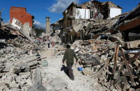 Un hombre camina entre los escombros de las viviendas tras un terremoto 6,2. que sacudió el centro de Italia, en Pescara del Tronto. 24 de agosto de 2016. Un devastador terremoto sacudió el miércoles varias localidades del centro de Italia, dejando al menos 120 personas muertas, residentes atrapados bajo los escombros y un número indeterminado de desaparecidos. REUTERS/Remo Casilli