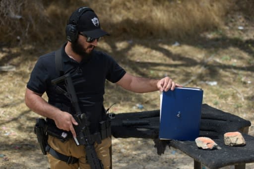 Rabbi Raziel Cohen shows how bullets from an AR-15 style semi-automatic rifle went through a book during a demonstration at the Angeles Shooting Ranges in Pacoima, California on May 20, 2019