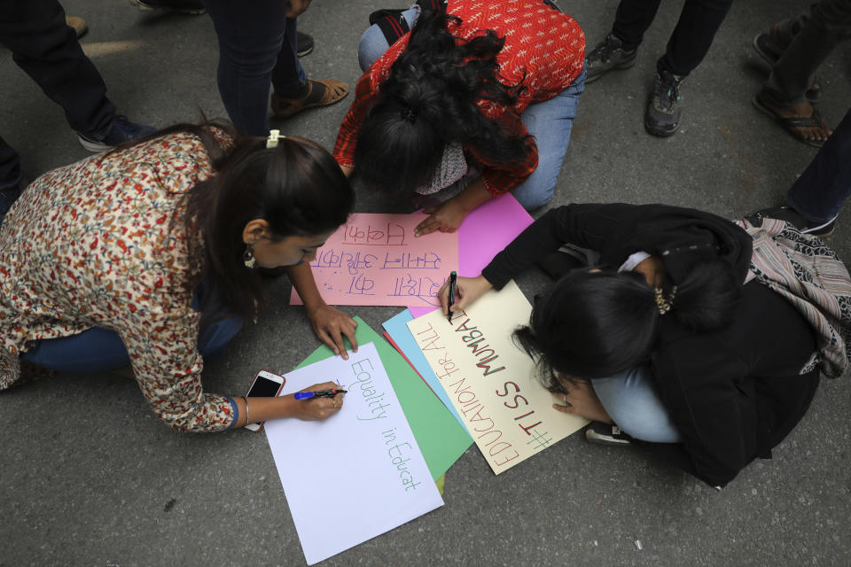 Indian students write placards as they join a protest march towards the Parliament in New Delhi, India, Saturday, Nov. 23, 2019. Hundreds of students of the Jawaharlal Nehru University were joined by students from other universities, activists and members of civil society as they marched towards India's parliament to protest against the hostel fee hike, along with their other demands. (AP Photo/Altaf Qadri)
