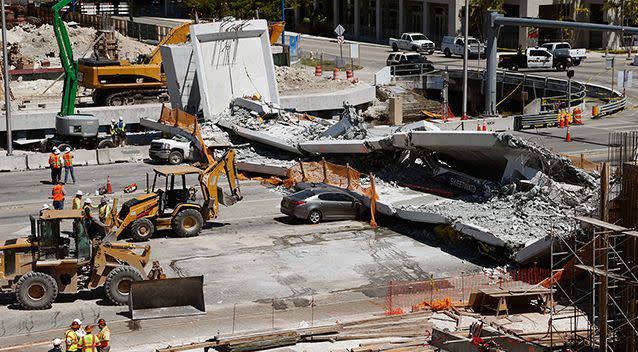 Crushed cars lie under a section of a collapsed pedestrian bridge near Florida International University. Source: AP via AAP