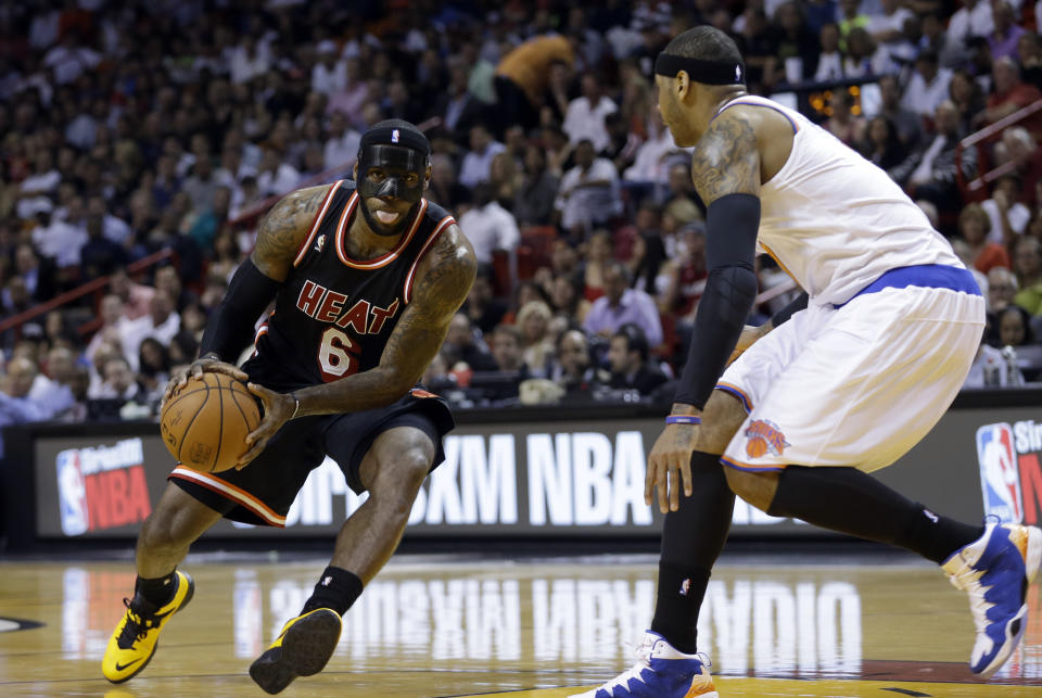 Miami Heat small forward LeBron James (6) drives as New York Knicks small forward Carmelo Anthony (7) defends during the first half of an NBA basketball game in Miami, Thursday, Feb. 27, 2014. (AP Photo/Alan Diaz)