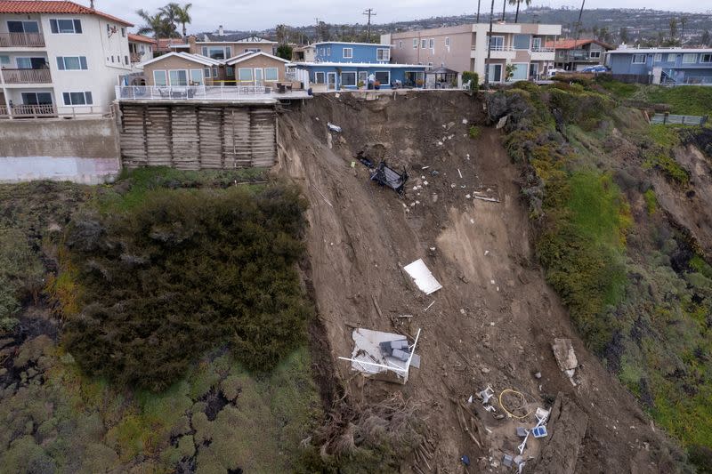 FILE PHOTO: A backyard pool hangs on cliffside after torrential rains hits California beachtown