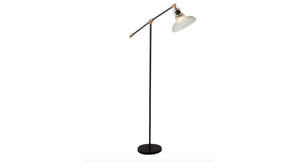 We love the matte black finish and antique brass metal accents on this floor lamp. 