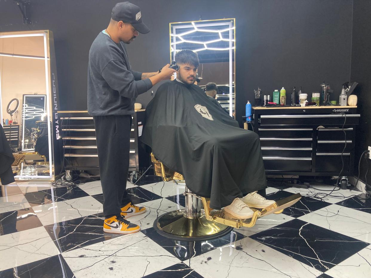 Barber Damian Deleon Milazzo gives brother Jack Milazzo a trim at the Fusion gym in Fairless Hills.