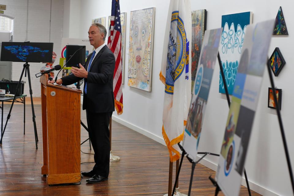 Various pieces of artwork hang on the wall as mayor Jon Mitchell and local arts leaders announce a dynamic new funding and support program for local artists at an event held at the Hatch Street Studios in New Bedford.