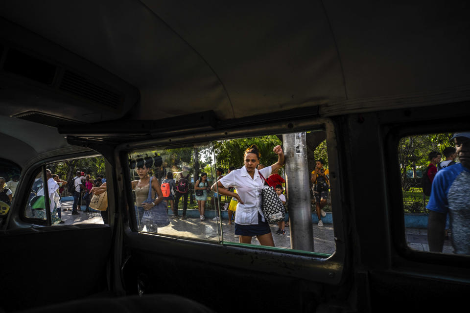 La gente espera en una parada de transporte público mientras mira un taxi colectivo en La Habana, Cuba, el martes 4 de abril de 2023. (AP Foto/Ramón Espinosa)