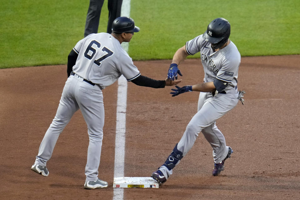 New York Yankees' Giancarlo Stanton, right, rounds third to greetings from coach Luis Rojas after hitting a solo home run off Pittsburgh Pirates starting pitcher Luis Ortiz during the third inning of a baseball game in Pittsburgh, Saturday, Sept. 16, 2023. (AP Photo/Gene J. Puskar)