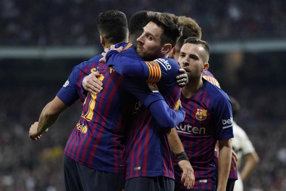 Barcelona forward Lionel Messi, center, celebrates with Barcelona forward Luis Suarez celebrates after Real defender Raphael Varane scores an own goal during the Copa del Rey semifinal second leg soccer match between Real Madrid and FC Barcelona at the Bernabeu stadium in Madrid, Spain, Wednesday Feb. 27, 2019. (AP Photo/Andrea Comas)