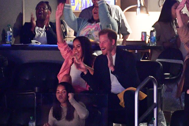 Allen Berezovsky/Getty Images Prince Harry and Meghan Markle watch the L.A. Lakers