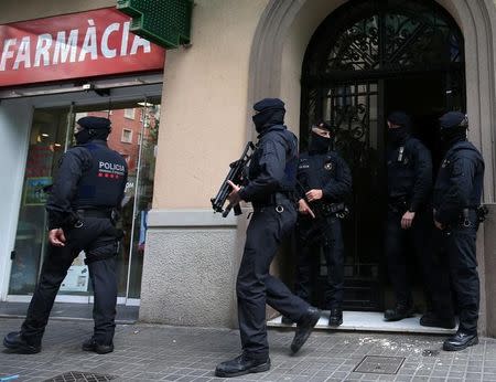 Spanish police stand guard outside an apartment building during a sweeping operation at some 12 locations against Islamist militants, in which eight people were arrested, in Barcelona, Spain, April 25, 2017. REUTERS/Albert Gea