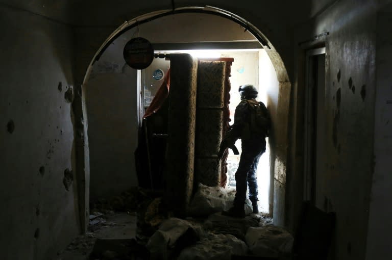 A member of the Iraqi forces, consisting of the Iraqi federal police and the elite Rapid Response Division, secures a building as troops push into the Old City in Mosul on March 19, 2017