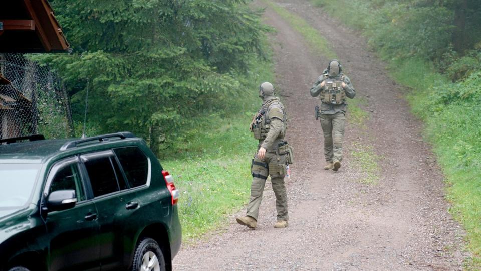 Polizisten gehen bei Oppenau durch ein Waldgebiet. Mit einem Großaufgebot wird nach dem Flüchtigen gesucht.