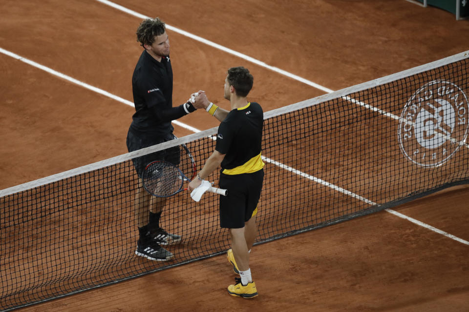 El austriaco Dominic Thiem (plano alto) saluda al argentino Diego Schwartzman tras la victoria de éste en lo cuartos de final del Abierto de Francia, el martes 6 de octubre de 2020, en París. (AP Foto/Alessandra Tarantino)