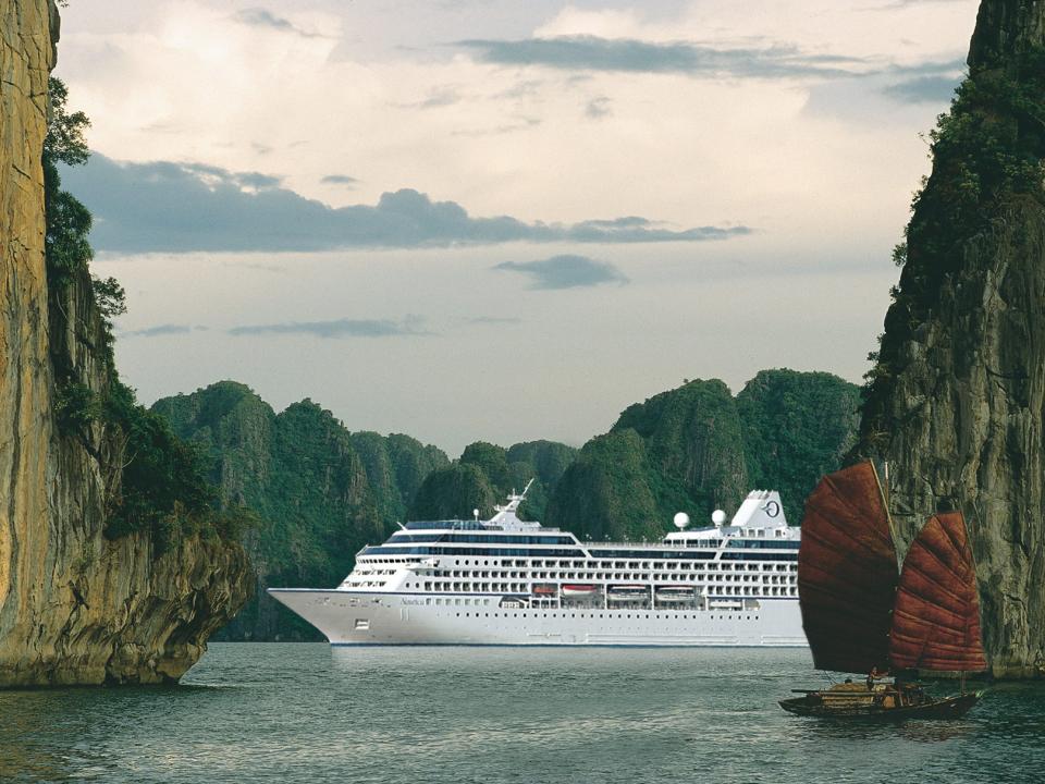 The Insignia sailing on water surrounded by tall cliffs.