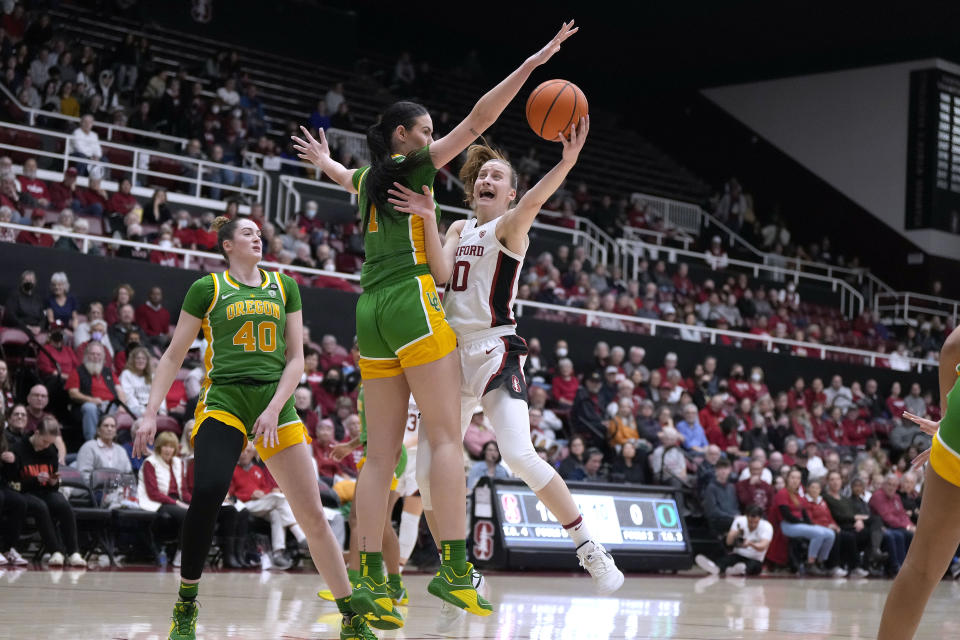 Stanford guard Elena Bosgana (20) is fouled by Oregon forward Kennedy Basham (1) during the first half of an NCAA college basketball game Friday, Jan. 19, 2024, in Stanford, Calif. (AP Photo/Tony Avelar)