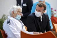 French President Emmanuel Macron, right, talks to a resident at the 'La Bonne Eure' nursing home in Bracieux, central France, Tuesday, Sept. 22, 2020. For the first time in months, virus infections and deaths in French nursing homes are on the rise again. (Yoan Valat/Pool Photo via AP)