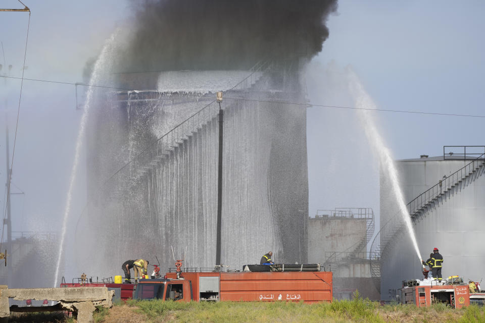 Firefighters work to extinguish a fire in an oil facility in the southern town of Zahrani, south of the port city of Sidon, Lebanon, Monday, Oct. 11, 2021. A huge fire broke out at an oil facility in southern Lebanon's coastal town of Zahrani, but the cause was not immediately known. (AP Photo/Hassan Ammar)