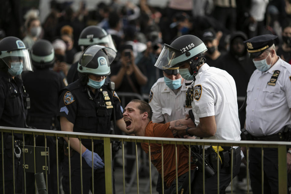 FILE — In this June 1, 2020 file photo, New York City Police officers arrest a man during a solidarity rally calling for justice over the death of George Floyd, in the Brooklyn borough of New York. The New York Police Department was caught off guard by the size and scope of the spring protests sparked by the police killing of George Floyd in Minneapolis and resorted to disorder control tactics that stoked tensions and stifled free speech rights, the city's inspector general said in a report released Friday, Dec. 18, 2020. (AP Photo/Wong Maye-E, File)