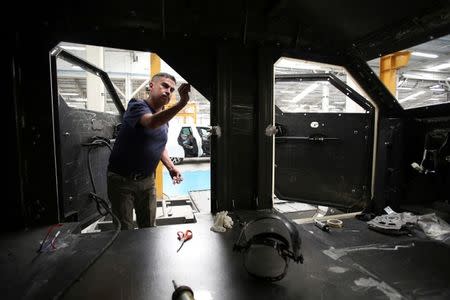 An employee works on the interior of an armored vehicle at the garage of Blindajes EPEL company in Mexico City, Mexico April 9, 2018. Picture taken April 9, 2018. REUTERS/Gustavo Graf