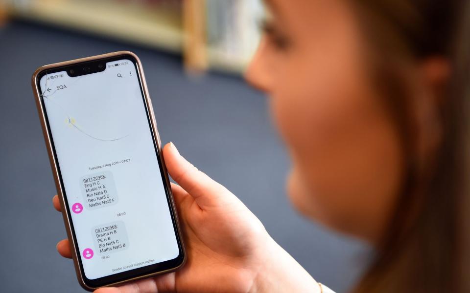 A school pupil in Scotland receives a text message detailing her exam results - Andy Buchanan/AFP