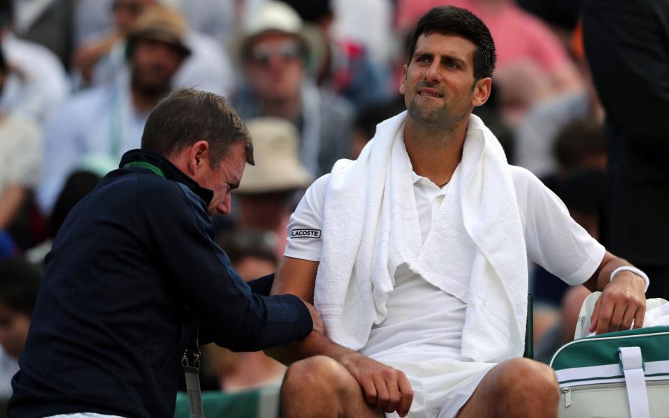 Novak Djokovic receives treatment at Wimbledon earlier this month  - PA