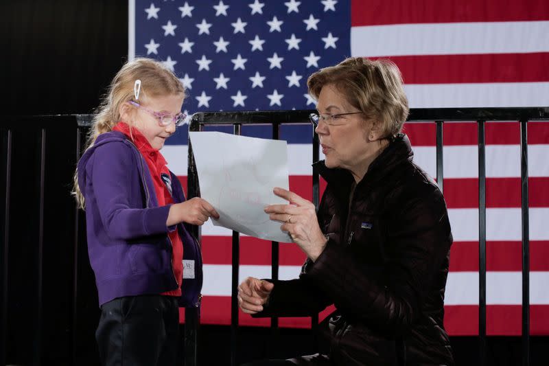 A girl shares her drawing with U.S. Democratic presidential candidate Senator Elizabeth Warren after a campaign town hall event at the Clark County Government Center Amphitheater in Las Vegas