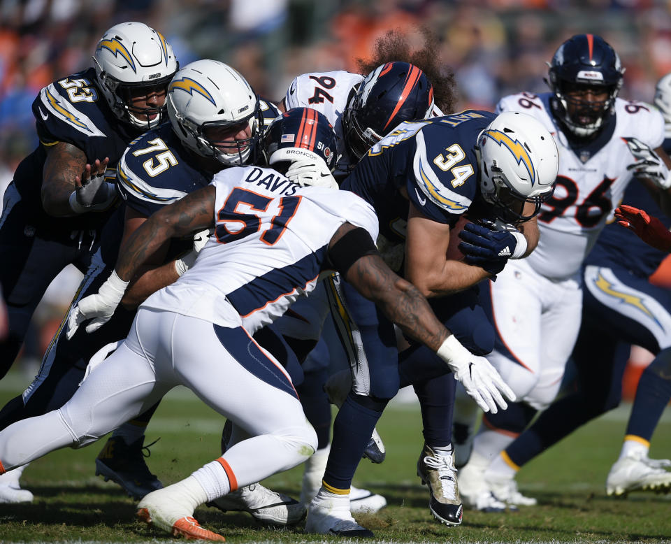 FILE - In this Sunday, Nov. 18, 2018, file photo, Los Angeles Chargers fullback Derek Watt, right, runs the ball while Denver Broncos nose tackle Domata Peko Sr., center, and linebacker Todd Davis defend during the first half of an NFL football game in Carson, Calif. Derek Watt and J.J. Watt have played against each other in the front and back yard of their parent’s home in Waukesha, Wisconsin. There will be bigger stakes and bragging rights on the line on Sunday, Sept. 22, 2019 when the Los Angeles Chargers host the Houston Texans.(AP Photo/Kelvin Kuo, File)