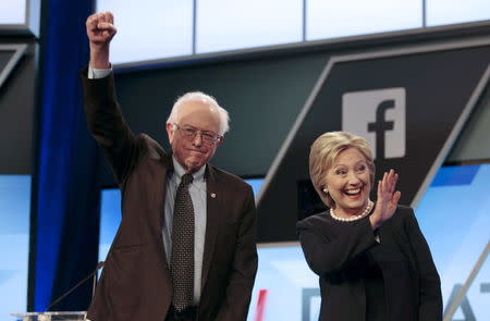 Democratic U.S. presidential candidates Senator Bernie Sanders and Hillary Clinton wave before the start of the Univision News and Washington Post Democratic U.S. presidential candidates debate in Kendall, Florida, March 9, 2016. REUTERS/Javier Galeano